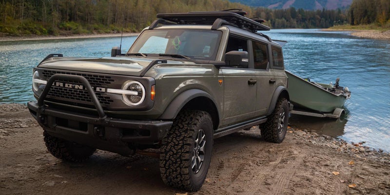 2026 Ford Bronco Badlands 4-Door towing a drift boat at a mountain river launch